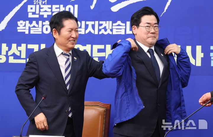 [서울=뉴시스] 조성봉 기자 = 정청래 더불어민주당 대표가 4일 오전 서울 여의도 국회에서 열린 중앙당공천관리위원회 공천 심사 발표에서 인천광역시장 후보로 확정된 박찬대 의원에게 잠바를 입혀주고 있다. 2026.03.04. suncho21@newsis.com