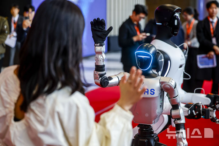 [서울=뉴시스] 정병혁 기자 = 4일 서울 강남구 코엑스에서 열린 2026 스마트공장·자동화산업전에서 직원이 유니트리의 휴머노이드 로봇 G1과 인사를 나누고 있다. 2026.03.04. jhope@newsis.com