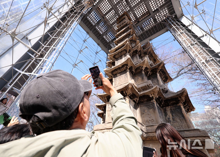 [서울=뉴시스] 이영환 기자 = 4일 오후 서울 종로구 탑골공원에서 시민들이 국보 2호 원각사지 십층석탑을 살펴보고 있다.종로구는 이날부터 15일까지 탑골공원 내 국보 2호 원각사지 십층석탑 내부를 시민에 공개한다. 1999년 산성비와 조류 배설물로부터 석탑을 보호하기 위해 유리 보호각을 설치한 이후 시민이 석탑 바로 앞까지 다가설 수 있게 된 것은 사실상 이번이 처음이다. 예약은 서울시 공공서비스예약 누리집을 통해 가능하며 1일 2회(회차별 최대 10명 선착순) 운영된다. 6,9,10일은 운영하지 않는다. 2026.03.04. 20hwan@newsis.com