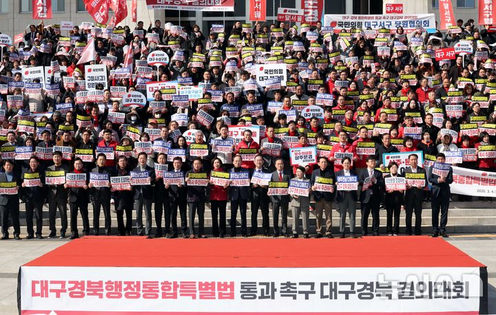 [서울=뉴시스] 조성봉 기자 = 이철우 경북도지사와 국민의힘 의원들을 비롯한 참석자들이 4일 오후 서울 여의도 국회 본청 계단에서 열린 '대구경북행정통합특별법 통과 촉구 대구경북 결의대회'에서 손피켓을 들고 구호를 외치고 있다. 2026.03.04. suncho21@newsis.com