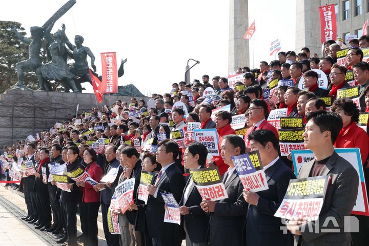 [서울=뉴시스] 조성봉 기자 = 이철우 경북도지사와 국민의힘 의원들을 비롯한 참석자들이 4일 오후 서울 여의도 국회 본청 계단에서 열린 '대구경북행정통합특별법 통과 촉구 대구경북 결의대회'에서 손피켓을 들고 있다. 2026.03.04. suncho21@newsis.com