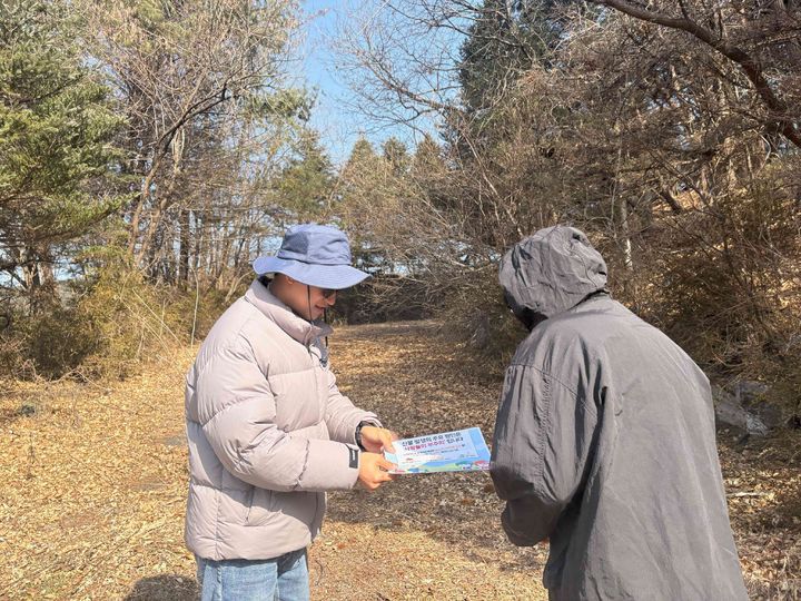 [횡성=뉴시스] 등산로 입구에서 산불 예방 수칙과 대처법이 담긴 팜플렛을 주민과 방문객에게 배포하는 모습. (사진=횡성숲체원 제공) 2026.03.05. photo@newsis.com *재판매 및 DB 금지