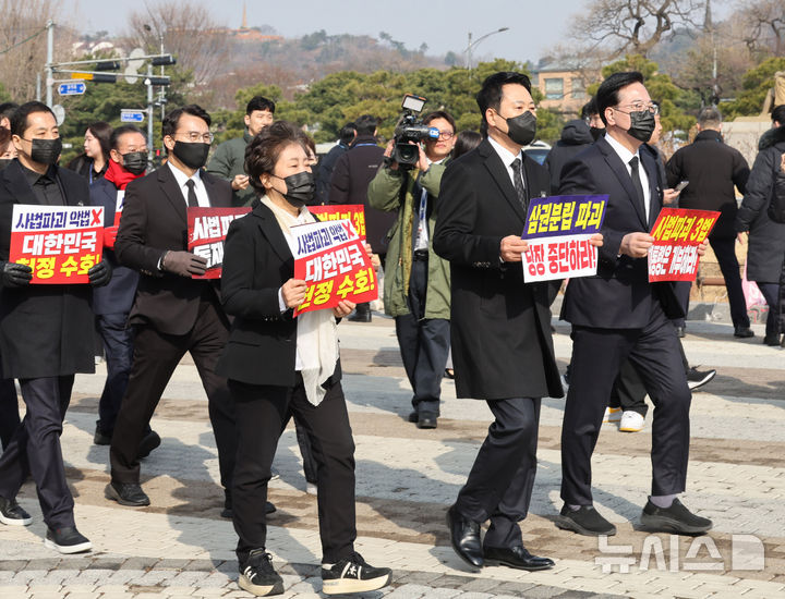 [서울=뉴시스] 배훈식 기자 = 장동혁 국민의힘 대표를 비롯한 소속 의원들이 5일 오전 서울 종로구 청와대 사랑채 분수대 앞에서 현장 의원총회를 마친 뒤 도보 행진을 하고 있다. 2026.03.05. dahora83@newsis.com