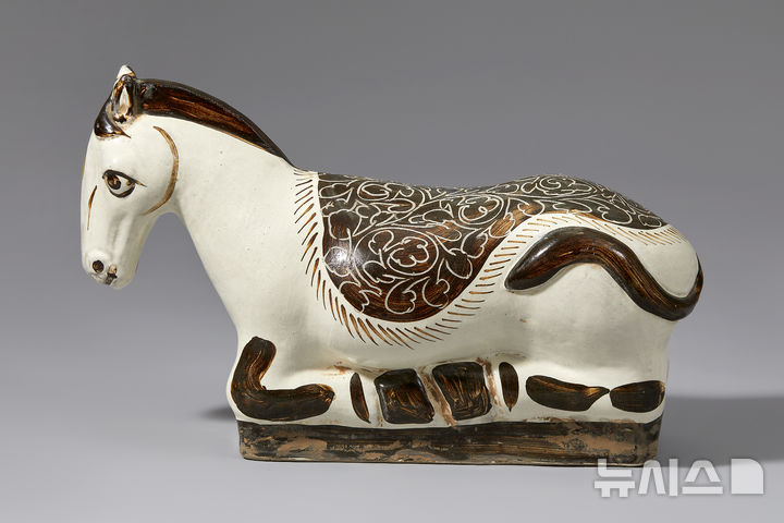 [서울=뉴시스] 박진희 기자 = 송 자주요 백지 흑화 마형 베개(960~1279). 말이 다리를 굽히고 앉은 자세로 표현된 자기 베개이다. 송대부터 금대, 원대에는 자주요(磁州窯)에서 일상용품으로 활용되는 자기를 주로 생산하였다. 특히 자기 베개의 생산은 대부분 자주요에서 일어났다. 이 말 베개는 전면을 백유로 시유한 뒤, 말의 등 위 화훼문(花卉)의 장식과 말의 얼굴, 갈기, 다리 등을 흑유로 채색하였다. (사진= 다보성갤러리 제공) 2026.03.06. photo@newsis.com