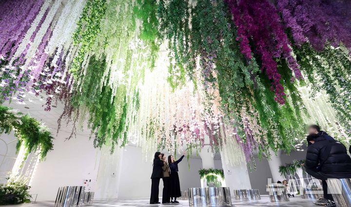 [부산=뉴시스] 하경민 기자 = 6일 부산 해운대구 신세계센텀시티 지하2층 중앙광장에 조성된 '하이퍼 가든'(Hyper Garden)을 찾은 시민들이 기념사진을 찍고 있다. 오는 5월까지 선보이는 하이퍼 가든은 '모네의 정원'을 테마로 수국, 등나무꽃, 델피늄 등의 화사한 꽃과 천장에서부터 내려오는 아치형 식물, 새 모형의 조명 등을 더해 봄 분위기를 연출했다. 2026.03.06. yulnetphoto@newsis.com