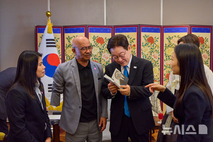 [서울=뉴시스] 최동준 기자 = 필리핀을 국빈 방문 중인 이재명 대통령이 4일 필리핀 마닐라 PRS 접견실에서 과거 특별한 인연이 있는 필리핀 노동자 아리엘 갈락 씨를 만나 '이재명 자서전'을 살펴보고 있다.&nbsp; 이 대통령은 인권 변호사 시절인 지난 1992년에 한국의 한 공장에서 근무하다가 불의의 사고를 당하고 보상을 받지 못한 채 필리핀으로 귀국한 그의 안타까운 사연을 접했다. 밤낮없이 일하다 한 팔을 잃은 채 강제 출국당한 그의 사정을 들은 이 대통령은 1년여의 재심 절차를 진행한 끝에 갈락 씨가 요양인정과 산업재해보상금을 받을 수 있게 도왔다. (공동취재) 2026.03.04. photocdj@newsis.com