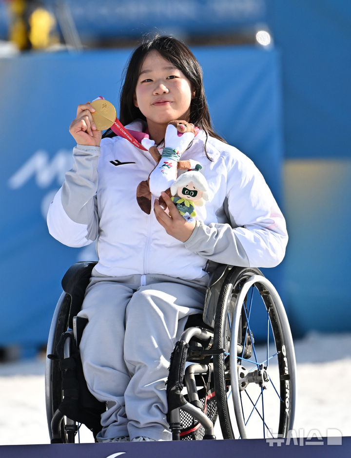 [테세로=뉴시스] 사진공동취재단 = 바이애슬론 김윤지가 8일(현지시간) 이탈리아 테세로 크로스컨트리 스키 스타디움에서 열린 2026 밀라노 코르티나 동계패럴림픽 바이애슬론 12.5km 시상식에서 금메달을 들어보이고 있다. 2026.03.08. photo@newsis.com