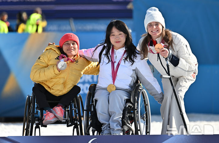 [테세로=뉴시스] 사진공동취재단 = 바이애슬론 김윤지(가운데)가 8일(현지시간) 이탈리아 테세로 크로스컨트리 스키 스타디움에서 열린 2026 밀라노 코르티나 동계패럴림픽 바이애슬론 12.5km 시상식에서 2위 비커 안야(독일, 왼쪽), 3위 그레치 켄달(미국)과 함께 메달을 들어 보이고 있다. 2026.03.08. photo@newsis.com