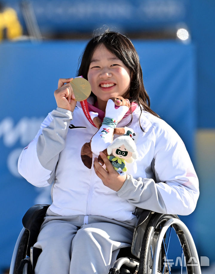 [테세로=뉴시스] 사진공동취재단 = 바이애슬론 김윤지가 8일(현지시간) 이탈리아 테세로 크로스컨트리 스키 스타디움에서 열린 2026 밀라노 코르티나 동계패럴림픽 바이애슬론 12.5km 시상식에서 금메달을 들어보이고 있다. 2026.03.08. photo@newsis.com