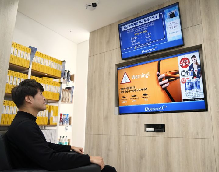 [사진=뉴시스] SK브로드밴드는 현대자동차 공식 차량정비 서비스 네트워크인 블루핸즈 매장에 디지털 사이니지 서비스 'B tv 온애드'를 구축했다고 9일 밝혔다. 사진은 블루핸즈 매장에 방문한 고객이 SK브로드밴드 'B tv 온애드' 화면을 바라보고 있는 모습. (사진=SKB 제공) 2026.03.09. photo@newsis.com *재판매 및 DB 금지