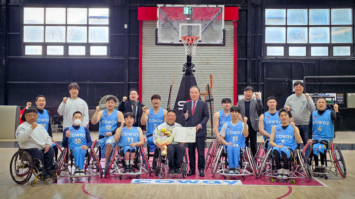 [서울=뉴시스] 지난 5일 안병태 한국휠체어농구연맹 총재가 코웨이 블루휠스 연습구장을 찾아 김영무 감독에게 표창과 꽃다발을 전달했다. (사진=코웨이 제공) 2026.03.09. photo@newsis.com *재판매 및 DB 금지