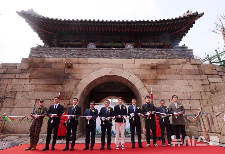 [서울=뉴시스] 이영환 기자 = 허민(왼쪽 다섯 번째부터) 국가유산청장, 방송인 파비앙 등 내빈들이 9일 오후 서울 종로구 창의문에서 열린 백악산 한양도성 안내소 개소식에서 테이프 커팅을 하고 있다. 2026.03.09. 20hwan@newsis.com