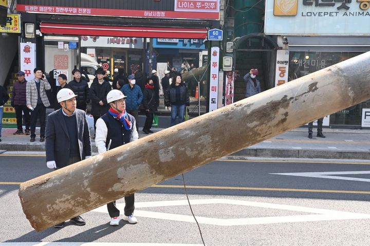 [하남=뉴시스] 10일 신장전통시장 인근에서 이현재 경기 하남시장과 시민들이 지켜보는 가운데 지중화 구간 첫 전주가 철거되고 있다. (사진=하남시 제공) 2026.03.10. photo@newsis.com&nbsp; *재판매 및 DB 금지