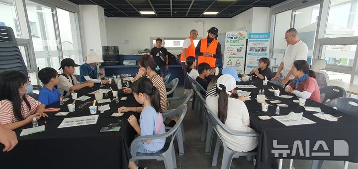 [서울=뉴시스] 씨글라스 체험을 하는 마을 관광객의 모습.