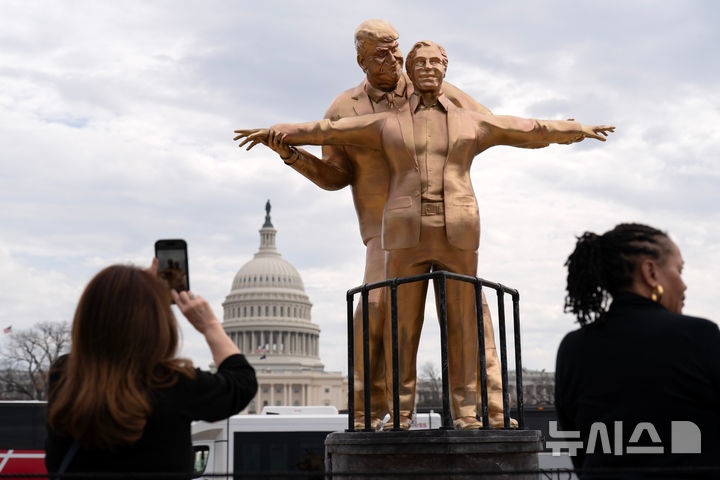 [워싱턴=AP/뉴시스] 도널드 트럼프 미국 대통령과 억만장자 성범죄자 제프리 엡스타인을 풍자하는 동상이 11일(현지 시간) 미국 워싱턴 D.C. 국회의사당 앞 내셔널몰에 세워져 있다. 2026.03.12.