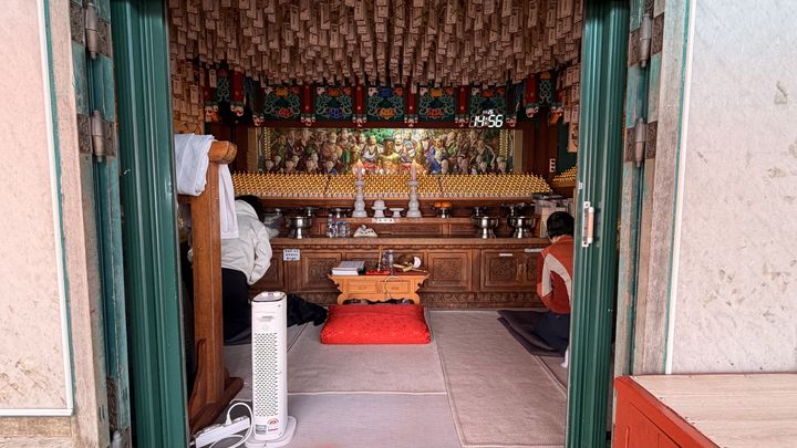 [서울=뉴시스] 김건민 인턴기자 = 연주대 축대 위에 위치한 응진전에서 두 여성이 절을 하고 있다. 2026.03.11. *재판매 및 DB 금지