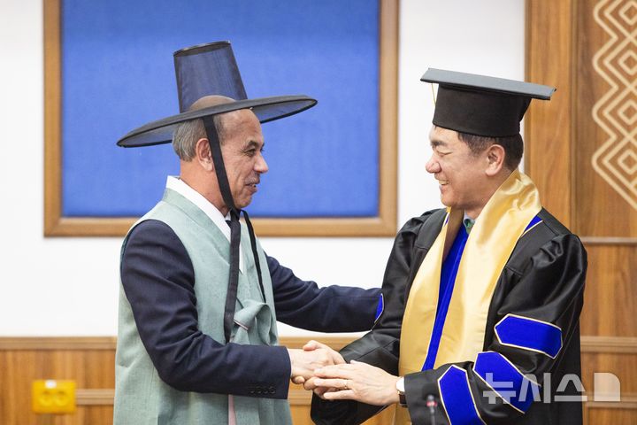 [평택=뉴시스] 정장선 평택시장이 대학 명예교수로 임명된 가운데, 평택시가 선물한 한복을 입은 툴킨 테샤바예프 총장과 악수를 나누고 있다. (사진=평택시 제공) 2026.03.12.photo@newsis.com 