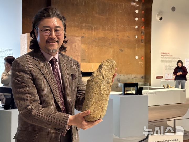 [연천=뉴시스] 한이재 기자 = 12일 이한용 전곡선사박물관장이 24차 발굴 조사에서 발견된 '초대형 주먹찌르개' 모형을 들어 보이고 있다. 2026.03.12. nowone@newsis.com