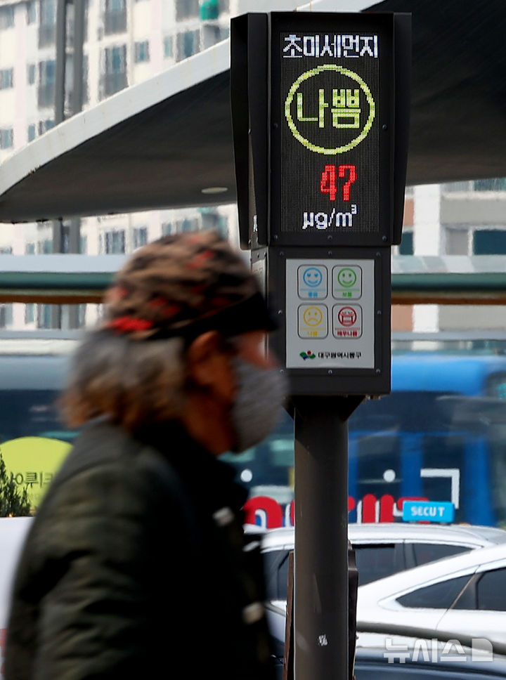 [대구=뉴시스] 이무열 기자 = 초미세먼지 농도가 ‘나쁨’ 수준을 보인 지난 12일 한 시민이 대구 동구 동대구역 광장에 설치된 미세먼지 알리미 앞을 지나고 있다. 2026.03.12. lmy@newsis.com