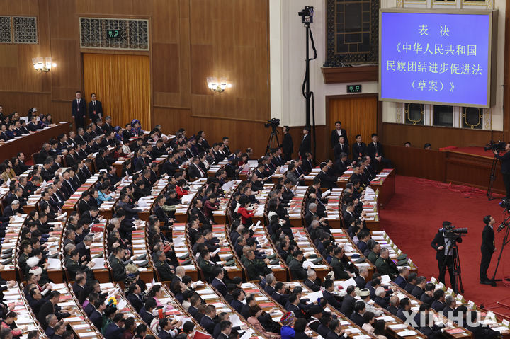 [베이징=신화/뉴시스] 12일 베이징 인민대회당에서 폐막한 전국인민대표대회에서 대표들이 '민족단결법'이 통과됐음을 알리는 안내를 보고 있다. 2026.03.12. 