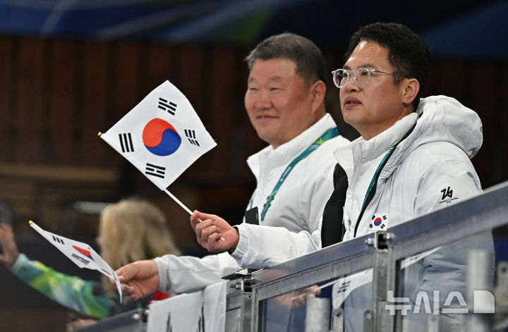 [코르티나담페초=뉴시스] 사진공동취재단 = 양오열(오른쪽) 선수단장과 전선주 선수촌장이 12일(현지 시간) 이탈리아 코르티나담페초 컬링 올림픽 스타디움에서 열린 2026 밀라노 코르티나 패럴림픽 휠체어컬링 혼성 4인조 캐나다와의 예선전에서 태극기를 흔들며 응원을 하고 있다. 2026.03.12. photo@newsis.com