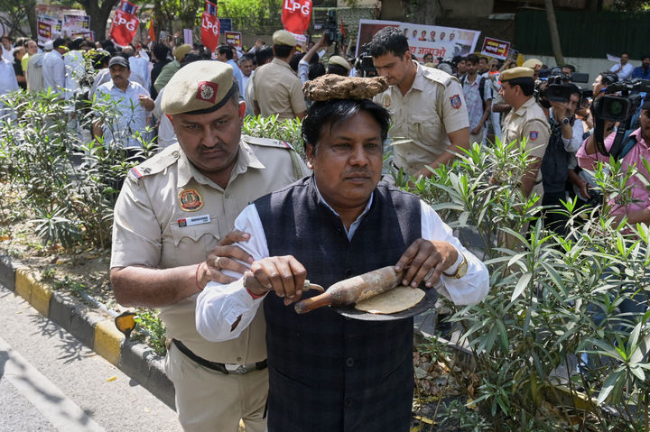 [뉴델리=AP/뉴시스] 지난 13일(현지 시간) 인도 뉴델리에서 액화석유가스(LPG) 부족에 항의하는 시위 도중 머리에 소똥을 이고 인도식 납작빵을 만드는 모습을 연출한 야당 당원을 경찰이 연행하는 모습. 2026.04.03. photo@newsis.com