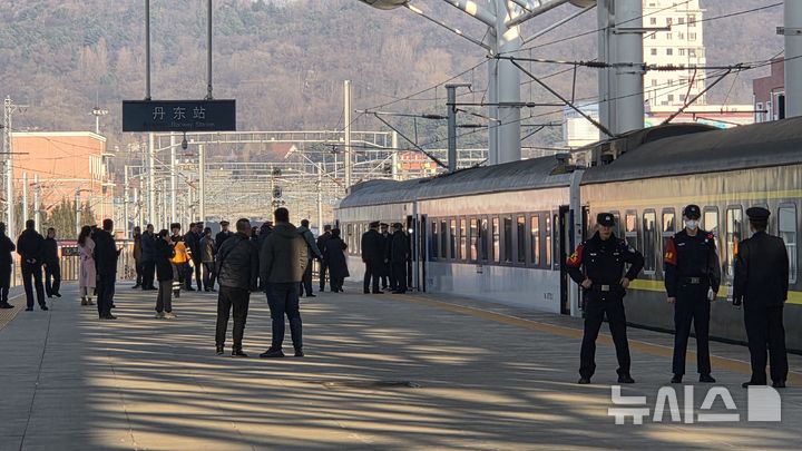 [베이징=뉴시스] 박정규 특파원 = 북·중 간 여객열차 운행이 재개된 가운데 베이징에서 평양으로 가는 K27편이 13일 오전 중국 랴오닝성 단둥역에 도착했다. 북한까지 가는 맨 끝 열차 2량 옆 플랫폼에 탑승객이 내리기를 기다리는 이들이 모여있다. 2026.03.13 pjk76@newsis.com