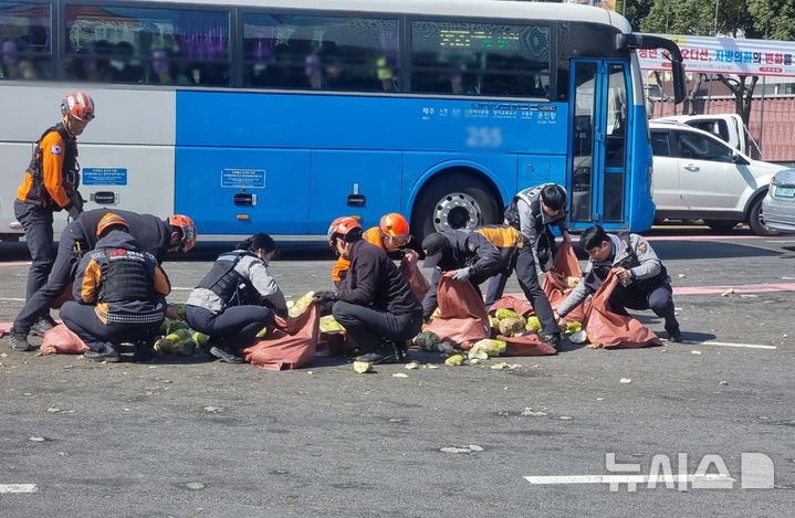 [제주=뉴시스] 13일 오후 2시께 제주시 노형오거리에서 화물차에 실려있던 월동무 약 2t이 도로에 떨어져 경찰과 소방당국이 수거하고 있다. (사진=제주소방안전본부 제공) 2026.03.13. photo@newsis.com 