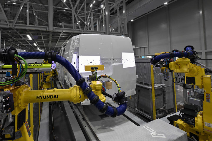 [화성=뉴시스] 기아 화성 EVO 플랜트 이스트(East)에서 로봇이 PV5 차체에 엠블럼을 부착하고 있다. 비전 카메라와 AI를 활용해 이물질을 확인하고 정확한 좌표를 맞출 수 있다.(사진=기아 제공) *재판매 및 DB 금지