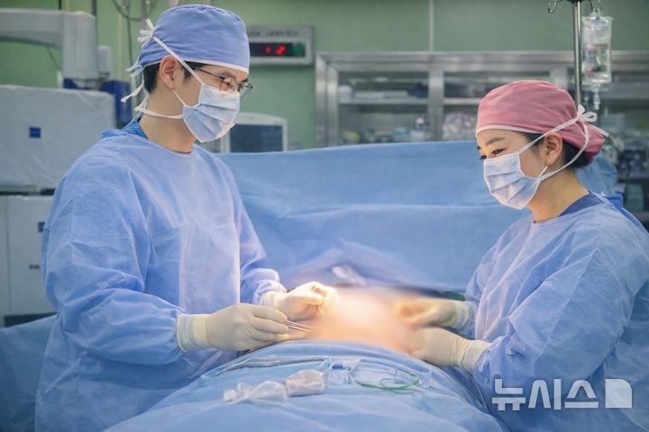 [서울=뉴시스] 김성환 한림대강남성심병원 성형외과 교수(왼쪽)와 안수경 외과 교수가 유방 동시 재건술을 하고 있다. (사진= 한림대강남성심병원 제공)