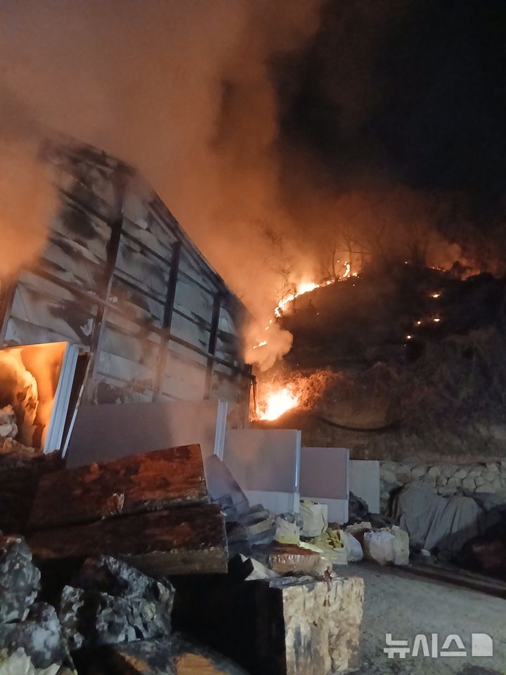 [충주=뉴시스] 13일 오후 9시2분께 충북 충주시 대소원면 탄용리의 한 폐기물 처리업체 창고에서 발생한 불이 인근 야산으로 옮겨 붙어 소방과 산림당국이 진화작업을 벌이고 있다. (사진=산림청 제공) 2026.03.13. photo@newsis.com