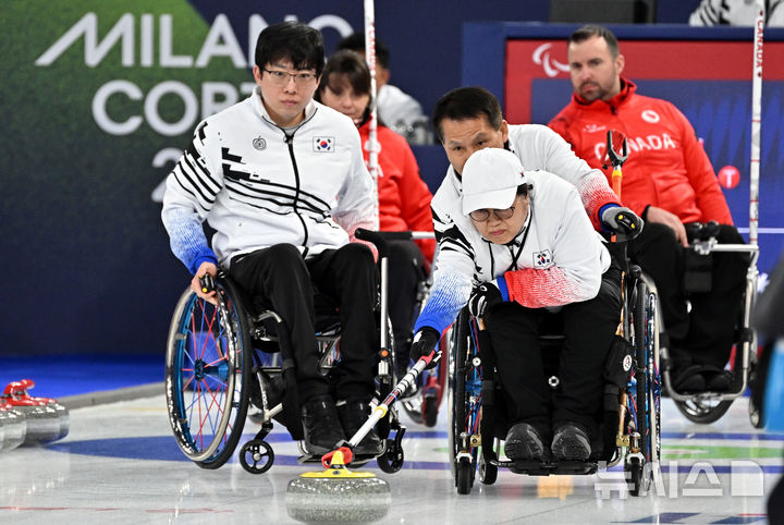 [코르티나담페초=뉴시스] 사진공동취재단 = 휠체어컬링 방민자(오른쪽)가 12일(현지 시간) 이탈리아 코르티나담페초 컬링 올림픽 스타디움에서 열린 2026 밀라노 코르티나 패럴림픽 휠체어컬링 혼성 4인조 캐나다와의 예선전에서 스톤을 힘차게 밀고 있다. 2026.03.13. photo@newsis.com