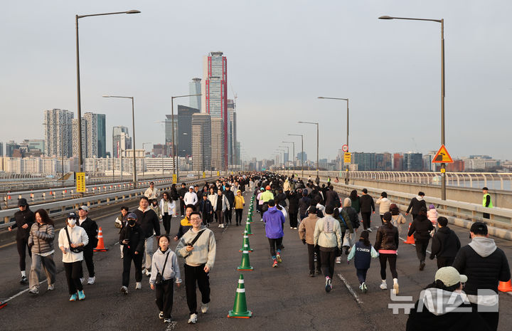 [서울=뉴시스] 황준선 기자 = 14일 오전 서울 마포대교 일대에서 도심 도로를 시민에게 개방하는 생활체육 프로그램 '쉬엄쉬엄 모닝' 행사 참가자들이 마포대교를 걷고 있다. 2026.03.14. hwang@newsis.com