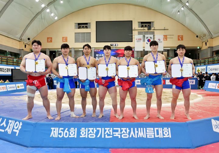 [서울=뉴시스] 15일 경상북도 문경시 문경실내체육관에서 열린 '제56회 회장기전국장사씨름대회' 대학교부 개인전에서 1위를 차지한 조혁(호남대학교), 성민수(단국대학교), 하상원(영남대학교), 정택한(단국대학교), 김민규(동아대학교), 이수현(영남대학교), 도준수(인하대학교)이 메달을 메고 상장을 들고 다같이 기념사진을 찍고 있다. (사진=대한씨름협회 제공) 2026.03.15. photo@newsis.com *재판매 및 DB 금지