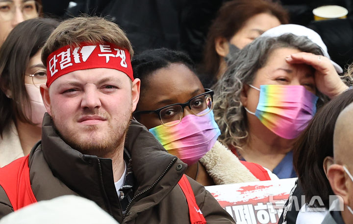 [서울=뉴시스] 최진석 기자 = 15일 서울 종로구 보신각 앞에서 열린 세계 인종차별 철폐의 날(3월 21일) 기념대회에서 한 참석자가 단결 투쟁 머리띠를 두르고 있다. 2026.03.15. myjs@newsis.com