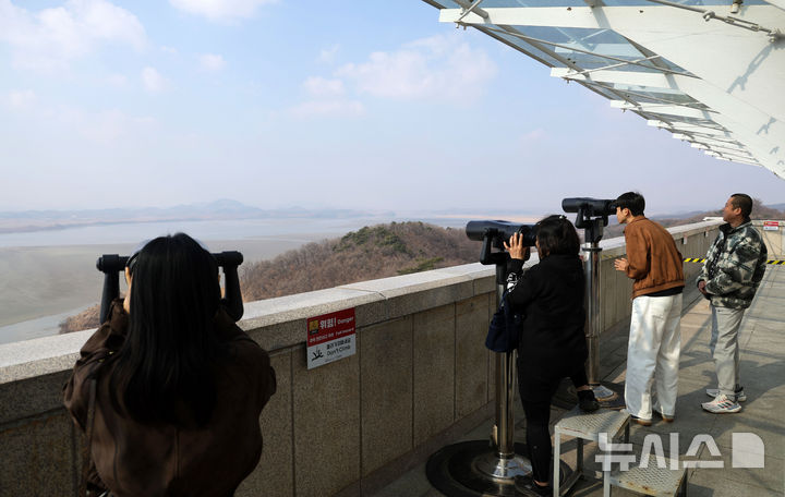 [파주=뉴시스] 홍효식 기자 = 북한 노동신문은 지난 14일 김정은 북한 국무위원장이 참관한 가운데 북한군 서부지구 장거리포명구분대의 600㎜ 초정밀다연장방사포 화력타격훈련이 실시됐다고 15일 보도했다. 김 위원장은 "우리에게 적개심을 가지고 있는 세력, 즉 420㎞ 사정권안에 있는 적들에게는 불안을 줄 것"이라고 말했다. 사진은 이날 경기도 파주시 오두산 통일전망대에서 관광객들이 북한 황해북도 개풍군 일대 마을을 바라보고 있다. 2026.03.15. yesphoto@newsis.com