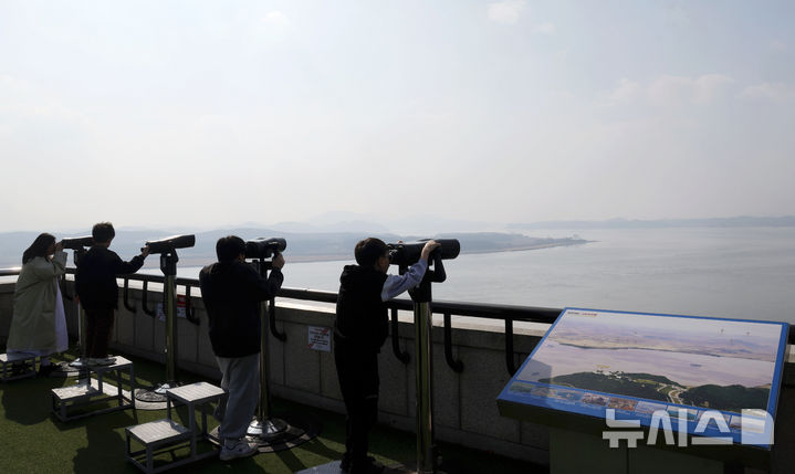 [파주=뉴시스] 홍효식 기자 = 북한 노동신문은 지난 14일 김정은 북한 국무위원장이 참관한 가운데 북한군 서부지구 장거리포명구분대의 600㎜ 초정밀다연장방사포 화력타격훈련이 실시됐다고 15일 보도했다. 김 위원장은 "우리에게 적개심을 가지고 있는 세력, 즉 420㎞ 사정권안에 있는 적들에게는 불안을 줄 것"이라고 말했다. 사진은 이날 경기도 파주시 오두산 통일전망대에서 관광객들이 북한 황해북도 개풍군 일대 마을을 바라보고 있다. 2026.03.15. yesphoto@newsis.com