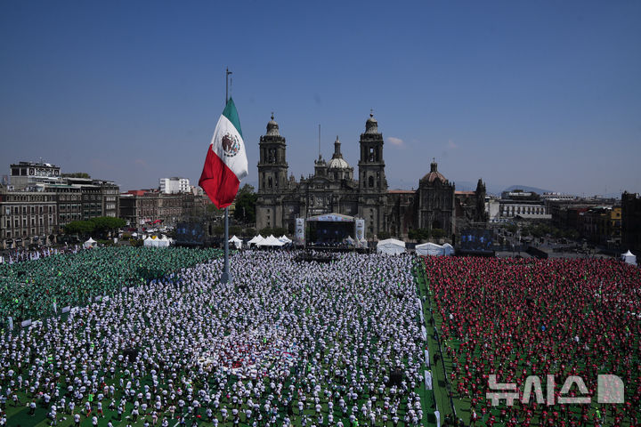 [멕시코시티=AP/뉴시스] 15일(현지 시간) 멕시코 수도 멕시코시티 소칼로 광장에서 열린 세계 최대 규모 축구 수업에 참여한 시민들이 기네스 세계 기록에 도전하고 있다. 2026.03.16.