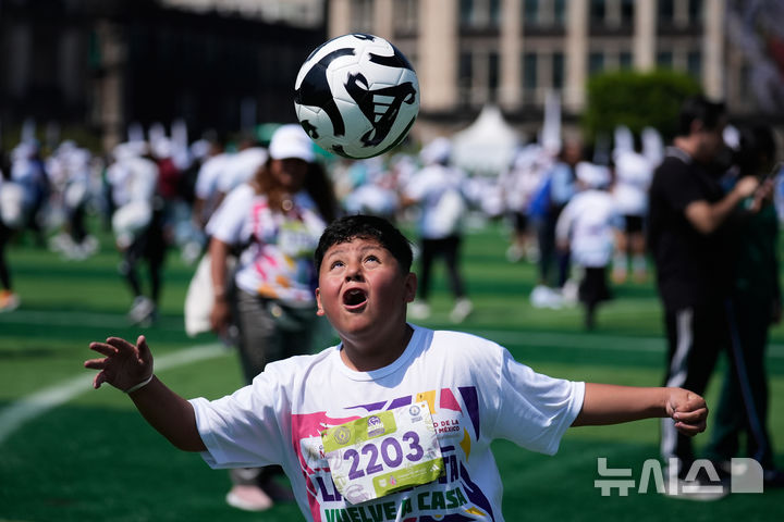[멕시코시티=AP/뉴시스] 15일(현지 시간) 멕시코 수도 멕시코시티 소칼로 광장에서 열린 세계 최대 규모 축구 수업에 참여한 시민들이 기네스 세계 기록에 도전하고 있다. 2026.03.16.