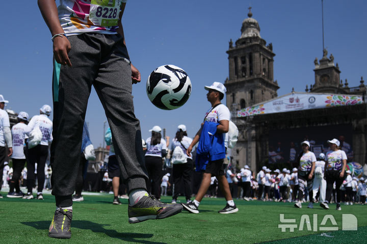 [멕시코시티=AP/뉴시스] 15일(현지 시간) 멕시코 수도 멕시코시티 소칼로 광장에서 열린 세계 최대 규모 축구 수업에 참여한 시민들이 기네스 세계 기록에 도전하고 있다. 2026.03.16.