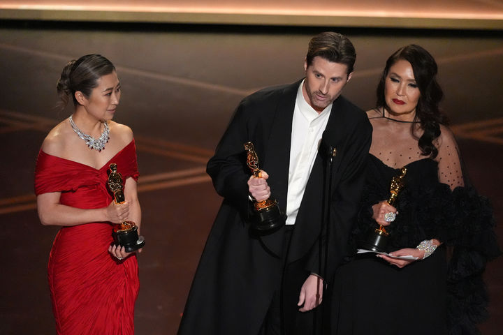 [로스앤젤레스=AP/뉴시스] 매기 강(왼쪽부터) 감독, 크리스 아펠한스 공동 연출자, L.M.웡 프로듀서가 15일(현지 시간) 미 캘리포니아주 로스앤젤레스 돌비 극장에서 열린 제98회 아카데미 시상식에서 케이팝 데몬 헌터스(케데헌)로 장편 애니메이션상을 받은 후 소감을 말하고 있다. 2026.03.16.