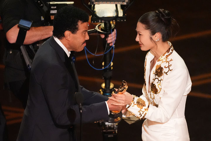 [로스앤젤레스=AP/뉴시스] 이재(EJAE, 오른쪽)가 15일(현지 시간) 미 캘리포니아주 로스앤젤레스 돌비 극장에서 열린 제98회 아카데미 시상식에서 가수 라이오넬 리치로부터 최우수 주제가상을 받고 있다. 이제는 케이팝 데몬 헌터스(케데헌) OST '골든'으로 상을 받았다. 2026.03.16.