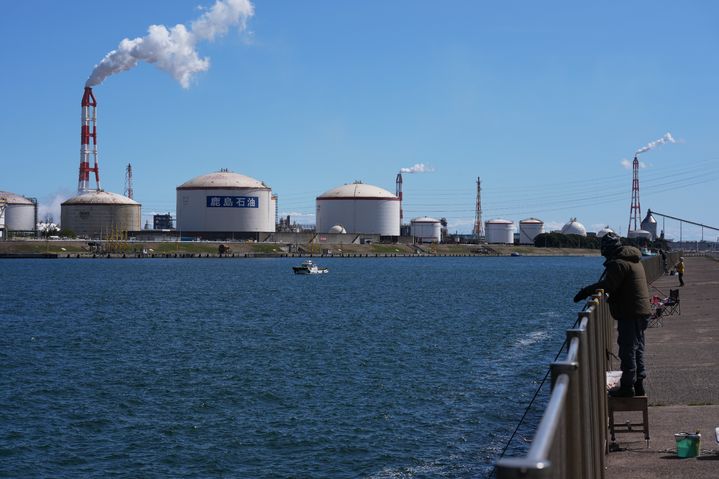 [가미스=AP/뉴시스]일본 정부는 이란 전쟁으로 급등한 유가 대응을 위해 2025회계연도(2025년 4월∼2026년 3월) 예산에서 예비비 약 8000억엔(약 7조5600억 원)을 지출할 방침을 굳혔다고 현지 공영 NHK가 23일 보도했다. 사진은 지난 15일 일본 도쿄 동쪽 가미스에서 지역 주민들이 부두에서 낚시를 하는 가운데 에네오스 그룹 가시마 정유공장에서 연기가 나오고 있는 모습. 2026.03.23.