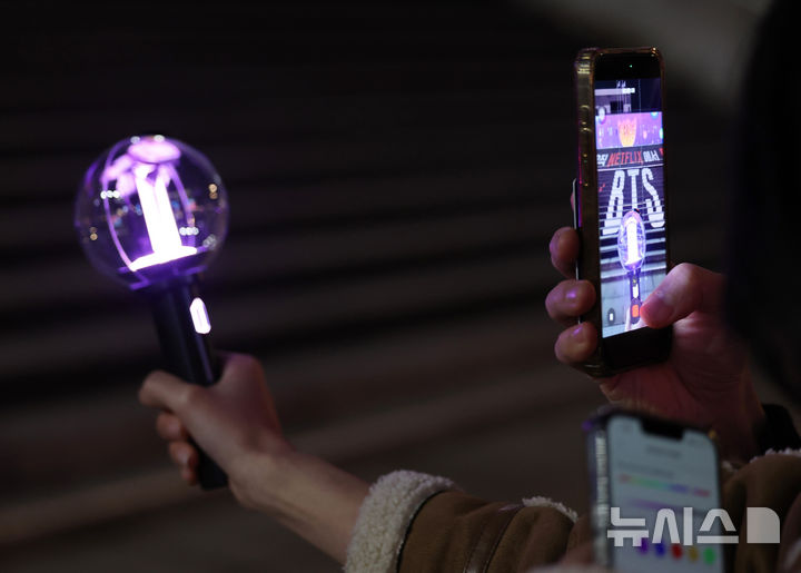 [서울=뉴시스] 김진아 기자 = 방탄소년단(BTS)의 서울 광화문광장 컴백 공연을 닷새 앞둔 16일 서울 종로구 광화문광장에서 팬들이 BTS 응원봉을 들고 기념촬영을 하고 있다. 2026.03.16. bluesoda@newsis.com