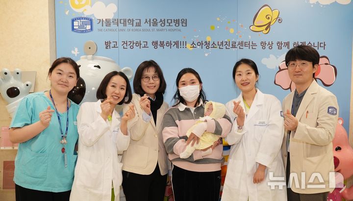 [서울=뉴시스] 서울성모병원에서 임신 23주 중 조기 분만으로 출생체중 500g의 초극소 미숙아로 태어난 주하(여아)가 6개월의 입원 생활을 마치고, 3월 17일 퇴원 후 첫 외래진료를 위해 병원을 찾았다. 왼쪽부터 김민수 교수, 조경아 신생아중환자실 UM 간호사, 주치의 김세연 교수, 주하 가족, 조성민 간호사, 김현호 진료전문의. (사진= 서울성모병원 제공) 