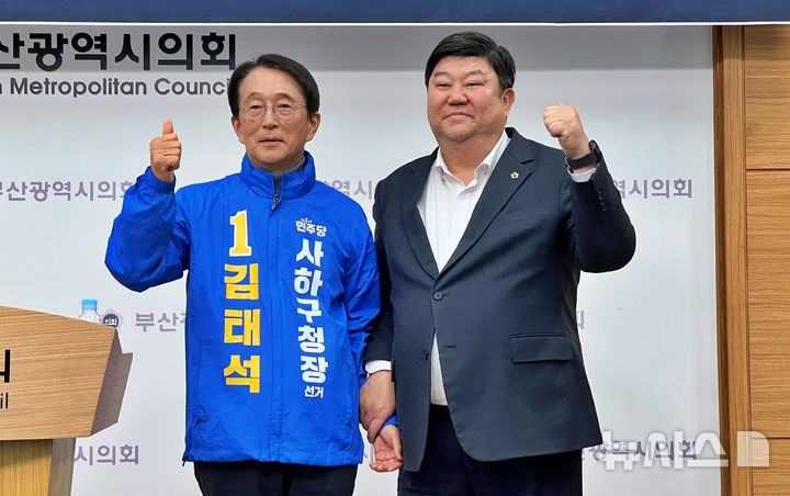 [부산=뉴시스] 원동화 기자 = 김태석 전 사하구청장(왼쪽)과 전원석 부산시의원이 17일 부산시의회 브리핑룸에서 단일화 발표를 한 뒤 파이팅을 외치고 있다. 앞서 전 의원은 김 전 구청장의 선거운동복을 직접 입혀주면서 지지를 선언했다. 2026.03.17. dhwon@newsis.com