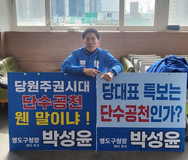 [부산=뉴시스] 박성윤 전 부산시의원이 영도구 공천에 반발해 피켓시위를 하고 있다. (사진=박성윤 전 부산시의원 제공) 2026.03.17. photo@newsis.com *재판매 및 DB 금지