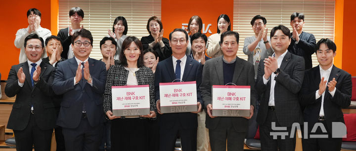 [창원=뉴시스]17일 BNK경남은행 창원 본점 회의실에서 초록우산어린이재단 조민정(앞줄 왼쪽서 세번째부터) 경남본부장, BNK경남은행 구태근 상무, ㈜아이엘씨 안일권 대표이사가 재난·재해 구호 KIT 지원 업무협약을 체결한 후 관계자들과 기념촬영하고 있다.(사진=BNK경남은행 제공) 2026.03.17. photo@newsis.com