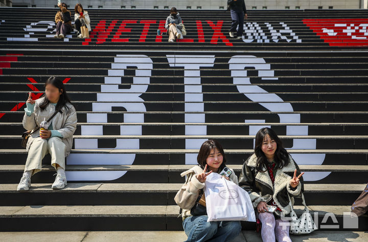[서울=뉴시스] 정병혁 기자 = 방탄소년단(BTS)의 서울 광화문광장 컴백 공연을 앞둔 지난 17일 서울 종로구 세종문화회관 계단을 찾은 일본인 팬들이 방탄소년단 랩핑 앞에서 사진을 찍고 있다. (사진은 기사와 직접 관련이 없습니다.) 2026.03.18. jhope@newsis.com