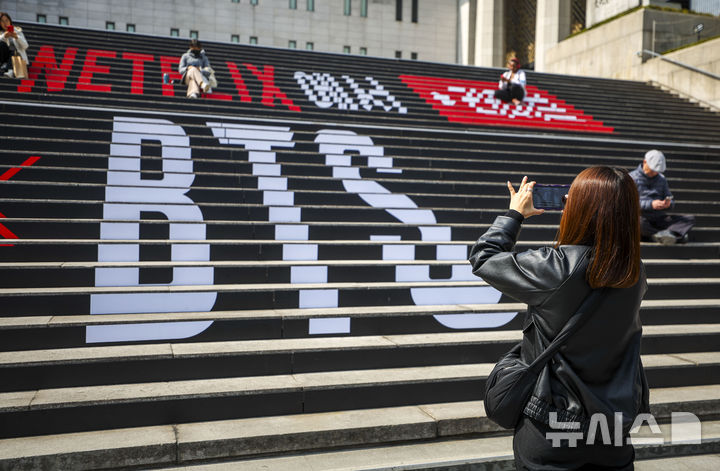 [서울=뉴시스] 정병혁 기자 = 방탄소년단(BTS)의 서울 광화문광장 컴백 공연을 앞둔 지난 17일 서울 종로구 세종문화회관 계단을 찾은 일본인 팬들이 방탄소년단 랩핑 앞에서 사진을 찍고 있다. 2026.03.18. jhope@newsis.com